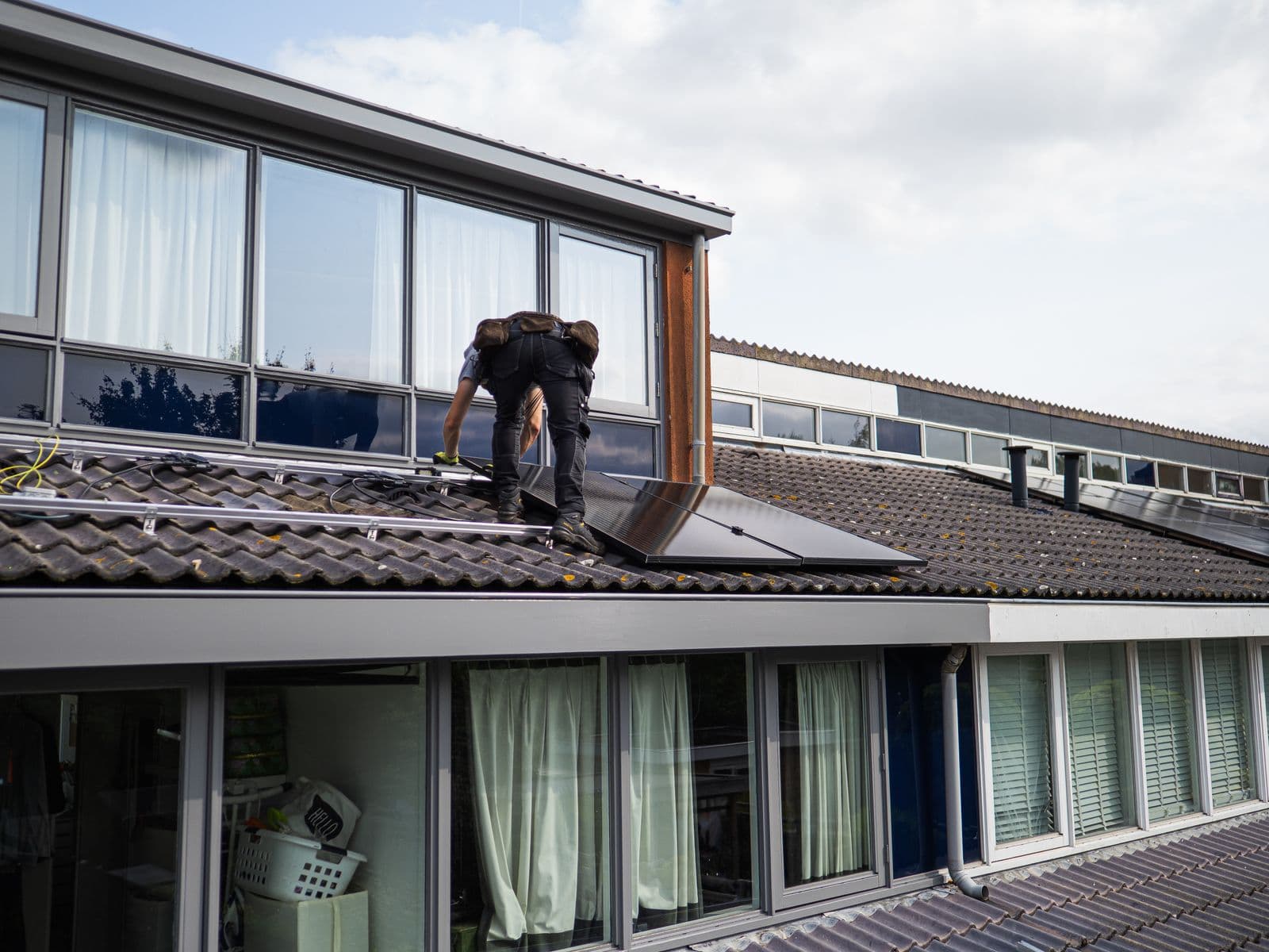 Monteur installeert zonnepanelen op een schuin dak
